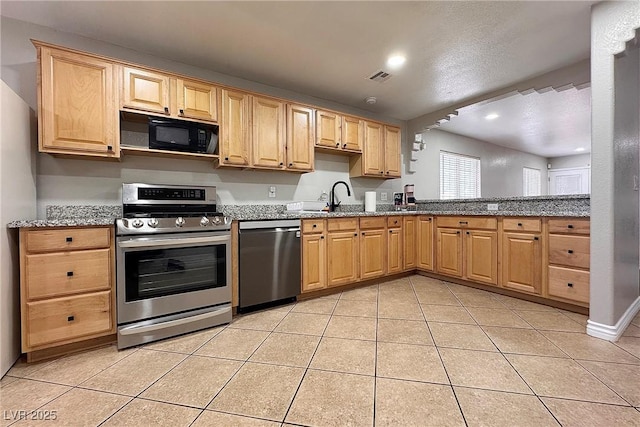 6929 Montcliff Ave, Las Vegas, NV 89147 - kitchen featuring appliances with stainless steel finishes, light tile patterned flooring, light brown cabinetry, stone counters, and a sink