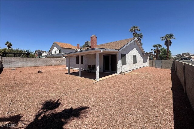 6929 Montcliff Ave, Las Vegas, NV 89147 - back of property with a patio area, a fenced backyard, a chimney, stucco siding, and central AC unit