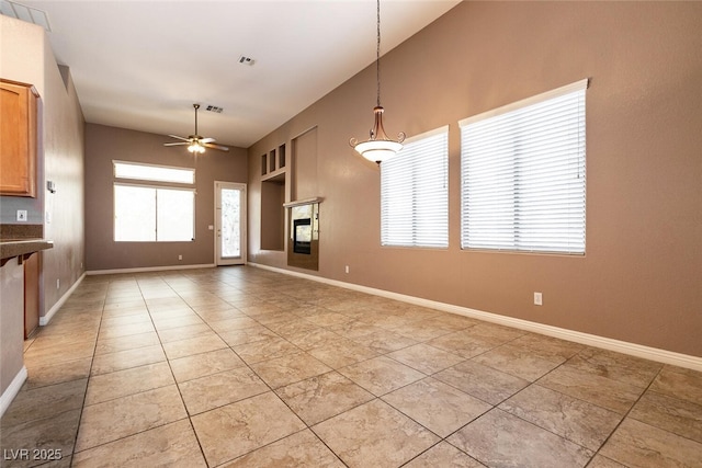 9025 Rusty Rifle Ave, Las Vegas, NV 89143 - unfurnished living room featuring a ceiling fan, light tile patterned floors, baseboards, and a glass covered fireplace