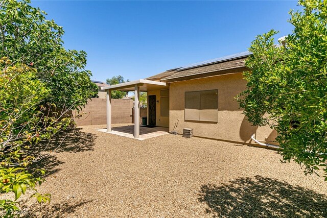 9025 Rusty Rifle Ave, Las Vegas, NV 89143 - back of house with stucco siding, roof mounted solar panels, and a patio