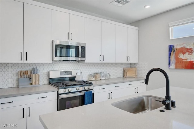 1321 Hudson Creek Pl, North Las Vegas, NV 89084 - kitchen with stainless steel appliances, a sink, light countertops, white cabinets, and recessed lighting