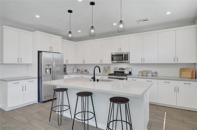 1321 Hudson Creek Pl, North Las Vegas, NV 89084 - kitchen with appliances with stainless steel finishes, a sink, backsplash, a kitchen breakfast bar, and recessed lighting