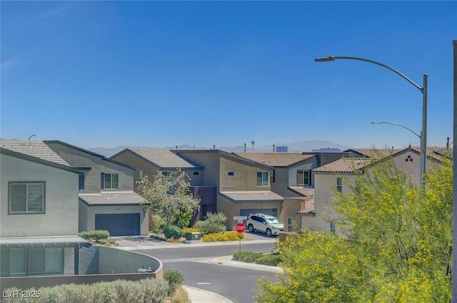 1321 Hudson Creek Pl, North Las Vegas, NV 89084 - view of asphalt road featuring street lighting, traffic signs, a residential view, and curbs