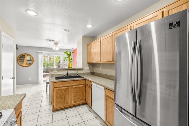 3464 Twilight Star Dr, Las Vegas, NV 89117 - kitchen featuring freestanding refrigerator, white dishwasher, a peninsula, light countertops, and light tile patterned flooring