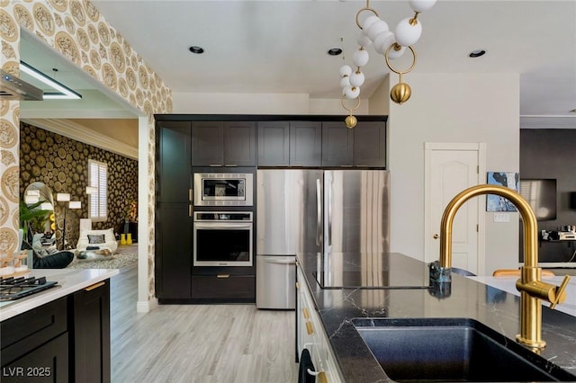 464 Beardsley Cir, Henderson, NV 89052 - kitchen with appliances with stainless steel finishes, a sink, wallpapered walls, light wood finished floors, and ornamental molding