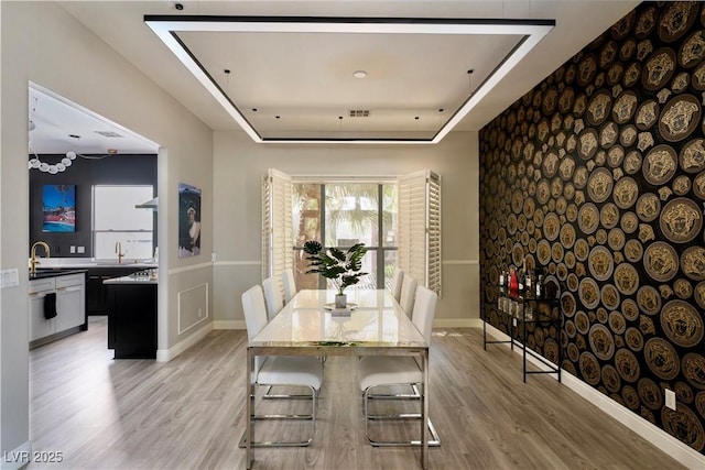 464 Beardsley Cir, Henderson, NV 89052 - dining room with light wood-type flooring, a raised ceiling, and baseboards