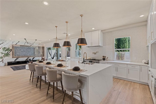 11550 Lampeter Ct, Las Vegas, NV 89138 - kitchen with a sink, light wood finished floors, recessed lighting, white cabinets, and a center island with sink
