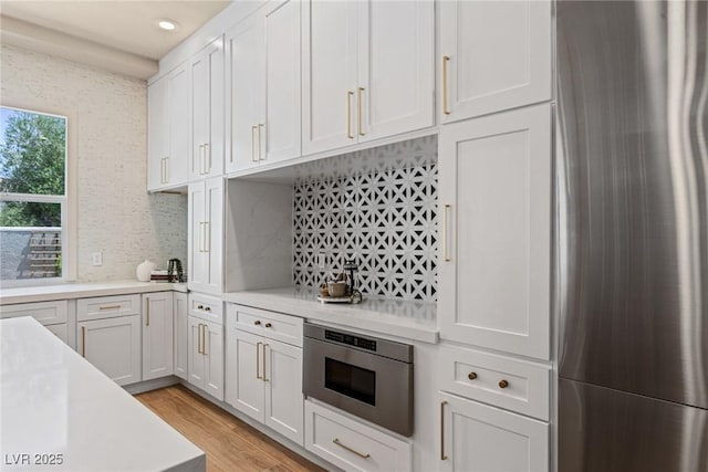11550 Lampeter Ct, Las Vegas, NV 89138 - kitchen with appliances with stainless steel finishes, light countertops, light wood-style flooring, white cabinets, and recessed lighting
