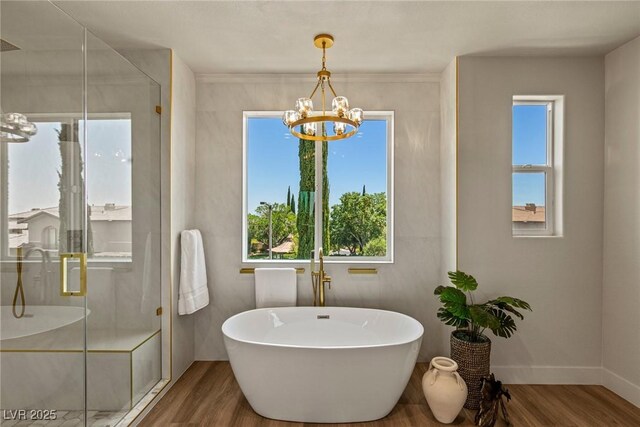 11550 Lampeter Ct, Las Vegas, NV 89138 - bathroom with a chandelier, wood finished floors, a stall shower, a freestanding tub, and plenty of natural light