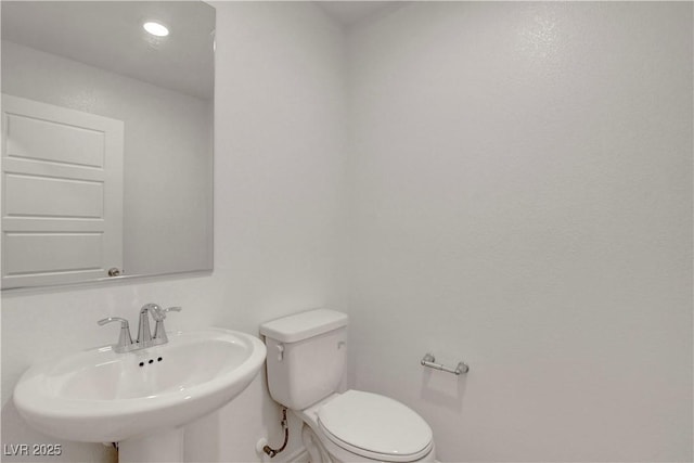10773 Bede Ct, Las Vegas, NV 89166 - half bath featuring a sink, toilet, and baseboards
