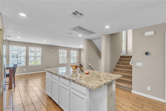 156 Campbelltown Ave, Henderson, NV 89015 - kitchen with wood finish floors, baseboards, white cabinets, recessed lighting, and a kitchen island