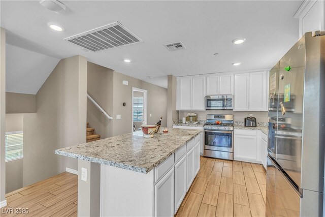 156 Campbelltown Ave, Henderson, NV 89015 - kitchen featuring appliances with stainless steel finishes, wood tiled floors, a kitchen island, white cabinets, and recessed lighting