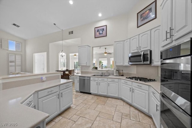 835 Market Crest Dr, Las Vegas, NV 89110 - kitchen with stainless steel appliances, light countertops, white cabinets, ceiling fan, and a towering ceiling