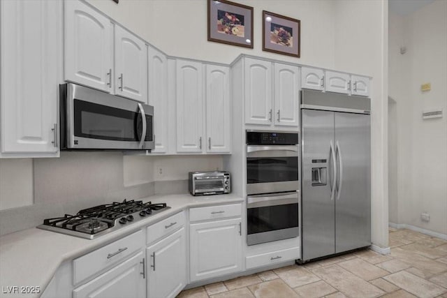 835 Market Crest Dr, Las Vegas, NV 89110 - kitchen with appliances with stainless steel finishes, white cabinets, light countertops, light stone finish flooring, and baseboards