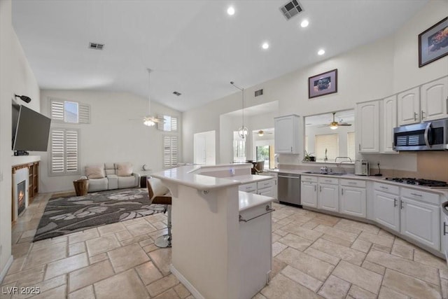835 Market Crest Dr, Las Vegas, NV 89110 - kitchen with stainless steel appliances, ceiling fan, high vaulted ceiling, open floor plan, and white cabinets