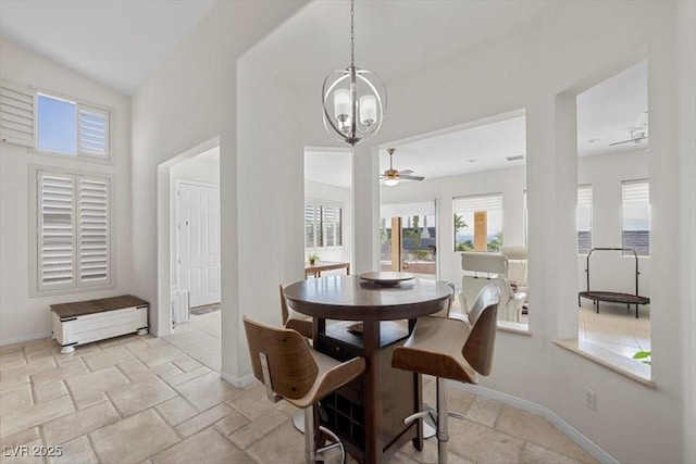 835 Market Crest Dr, Las Vegas, NV 89110 - dining room featuring a chandelier, baseboards, a ceiling fan, a towering ceiling, and light stone finish floors