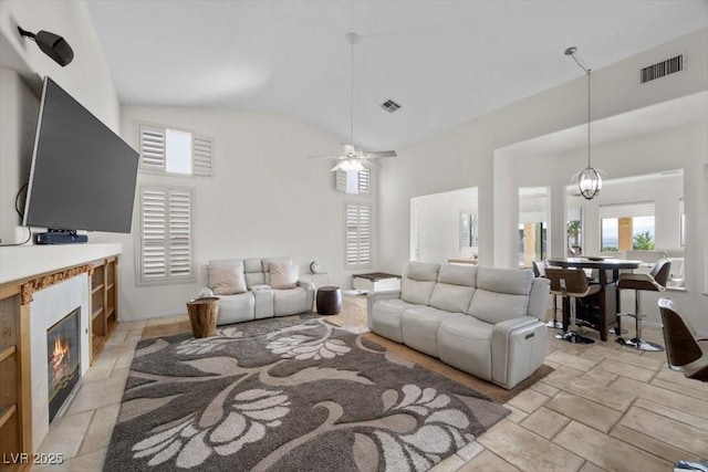 835 Market Crest Dr, Las Vegas, NV 89110 - living area with high vaulted ceiling, stone tile flooring, a glass covered fireplace, and ceiling fan