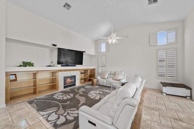835 Market Crest Dr, Las Vegas, NV 89110 - living area with stone tile floors, high vaulted ceiling, a ceiling fan, and a glass covered fireplace