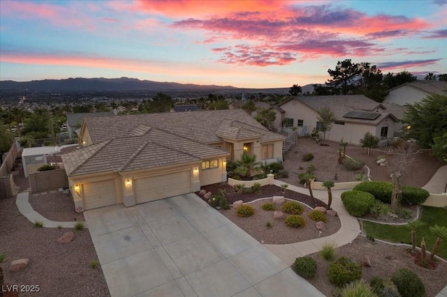 835 Market Crest Dr, Las Vegas, NV 89110 - view of front of property with a garage, driveway, a tile roof, stucco siding, and a mountain view