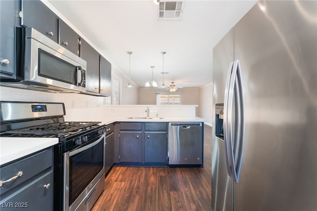 5524 La Pelusa St, North Las Vegas, NV 89031 - kitchen with appliances with stainless steel finishes, a sink, a peninsula, dark wood-style flooring, and light countertops