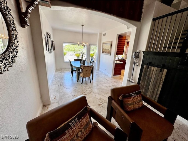 5041 Portraits Pl, Las Vegas, NV 89149 - foyer entrance with a chandelier, light marble finish floors, baseboards, arched walkways, and a fireplace