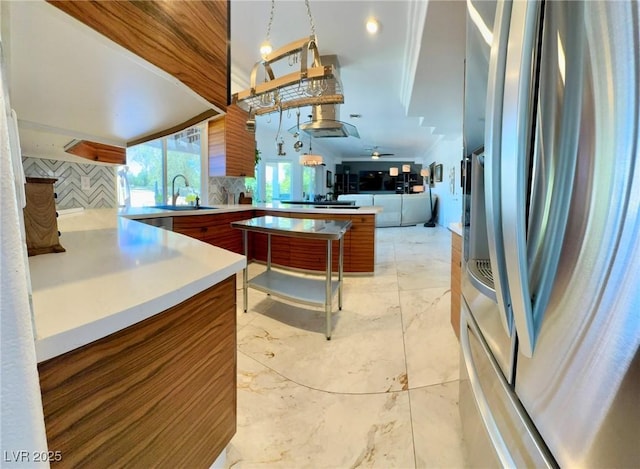 5041 Portraits Pl, Las Vegas, NV 89149 - kitchen featuring stainless steel refrigerator with ice dispenser, a sink, light countertops, backsplash, and open floor plan