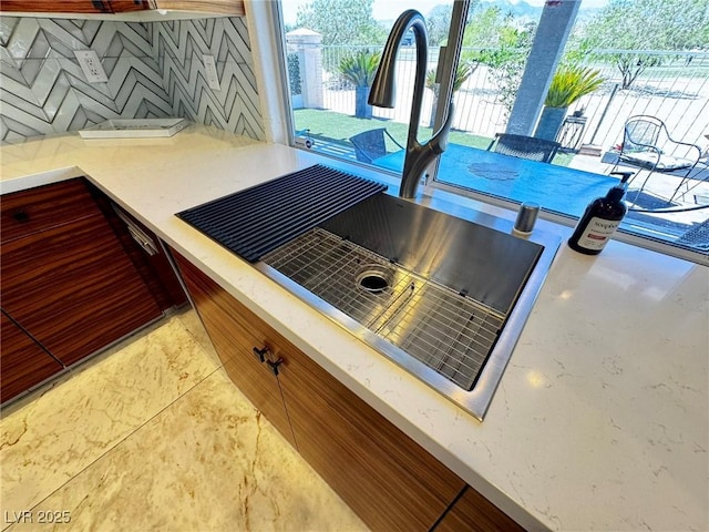 5041 Portraits Pl, Las Vegas, NV 89149 - kitchen view of a sink, decorative backsplash, and light stone countertops