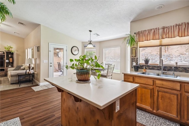574 Desert Tortoise Way, Mesquite, NV 89027 - kitchen with a sink, dark wood-style floors, light countertops, a textured ceiling, and brown cabinetry