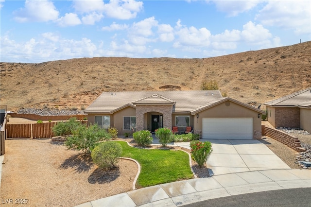 574 Desert Tortoise Way, Mesquite, NV 89027 - view of front of home with a tiled roof, a garage, stucco siding, and concrete driveway