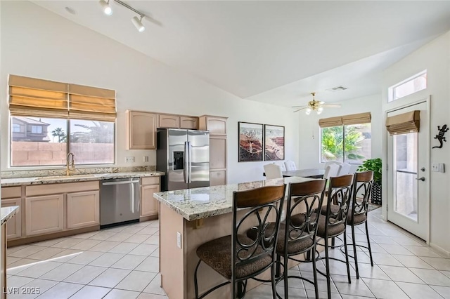 7515 Splashing Rock Dr, Las Vegas, NV 89131 - kitchen with appliances with stainless steel finishes, a sink, light tile patterned flooring, a kitchen breakfast bar, and a center island