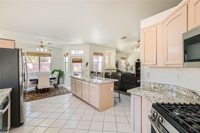 7515 Splashing Rock Dr, Las Vegas, NV 89131 - kitchen with ceiling fan, appliances with stainless steel finishes, light tile patterned floors, and open floor plan