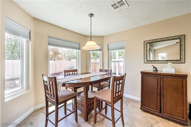 7641 Sea Wind Dr, Las Vegas, NV 89128 - dining space with plenty of natural light, a textured ceiling, baseboards, and light tile patterned floors