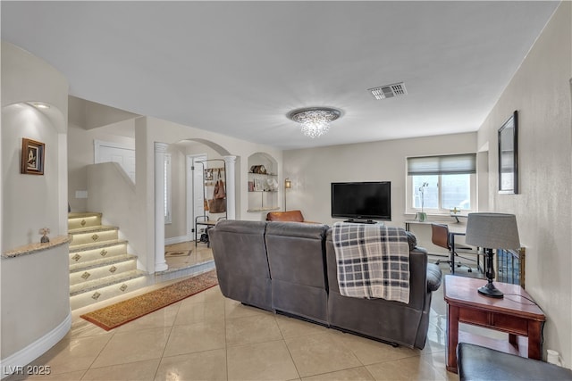 7197 Sixshooter Dr, Las Vegas, NV 89119 - living area featuring ornate columns, light tile patterned floors, arched walkways, stairs, and baseboards
