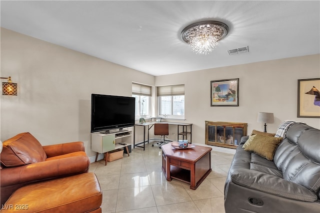 7197 Sixshooter Dr, Las Vegas, NV 89119 - living area with a chandelier, light tile patterned floors, baseboards, and a glass covered fireplace
