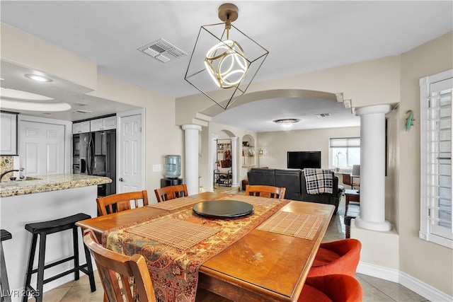 7197 Sixshooter Dr, Las Vegas, NV 89119 - dining area featuring decorative columns, arched walkways, light tile patterned flooring, and baseboards