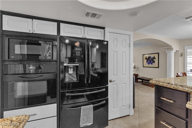 7197 Sixshooter Dr, Las Vegas, NV 89119 - kitchen featuring black appliances, light tile patterned floors, arched walkways, white cabinetry, and decorative columns