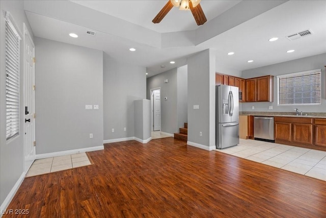5452 Tinker Toy Ave, Las Vegas, NV 89139 - kitchen with appliances with stainless steel finishes, a sink, light wood-style flooring, ceiling fan, and brown cabinets
