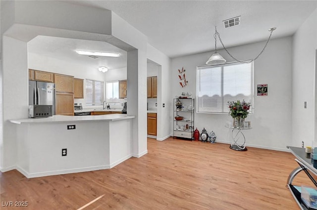 1025 Clover Tip Ct, Las Vegas, NV 89123 - kitchen featuring freestanding refrigerator, brown cabinets, a sink, light countertops, and light wood-style floors