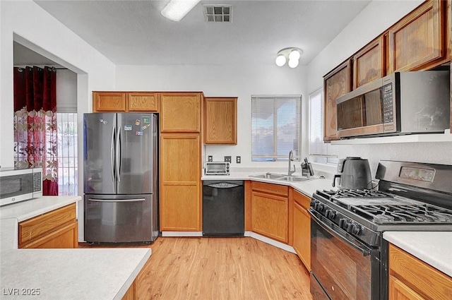 1025 Clover Tip Ct, Las Vegas, NV 89123 - kitchen featuring black appliances, a sink, healthy amount of natural light, and light wood-style floors