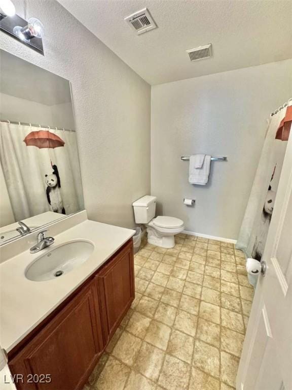 1355 Grass Creek Ave Unit 1, Henderson, NV 89012 - bathroom with toilet, vanity, a textured ceiling, a shower with curtain, and stone finish flooring