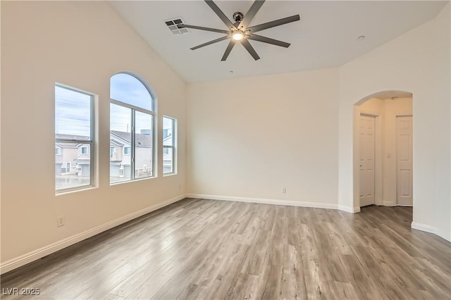 10147 Aspen Rose St Unit 101, Las Vegas, NV 89183 - spare room with arched walkways, a ceiling fan, high vaulted ceiling, wood finished floors, and baseboards