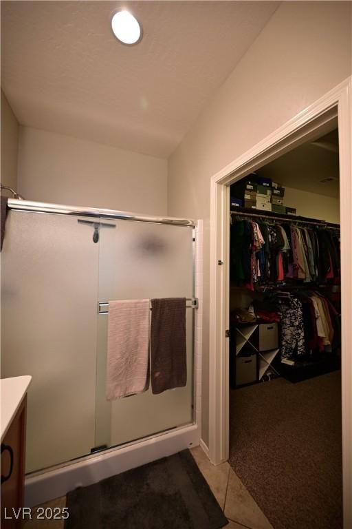 7727 Widewing Dr, North Las Vegas, NV 89084 - full bath featuring a shower stall, tile patterned floors, a spacious closet, and vanity