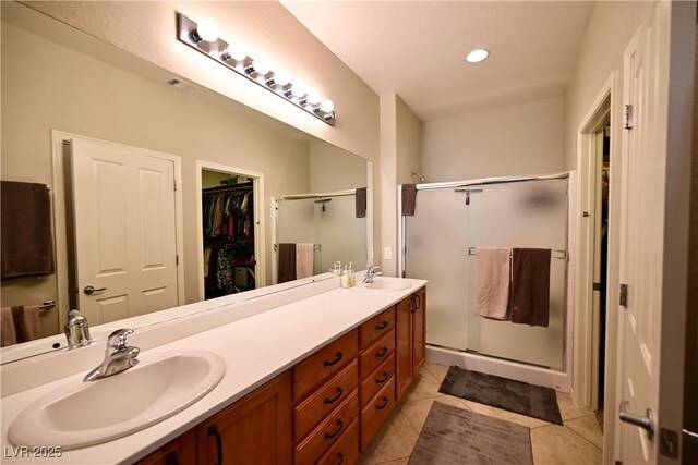 7727 Widewing Dr, North Las Vegas, NV 89084 - full bathroom featuring a shower stall, double vanity, a walk in closet, tile patterned floors, and recessed lighting