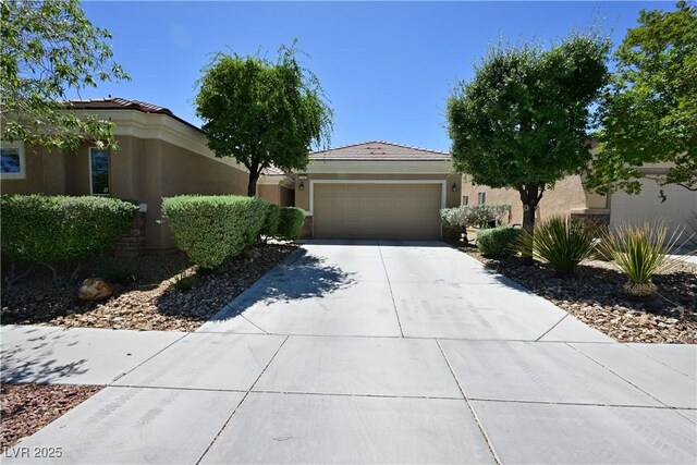 7727 Widewing Dr, North Las Vegas, NV 89084 - view of front facade featuring stucco siding, a garage, driveway, and a tile roof