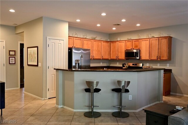 7727 Widewing Dr, North Las Vegas, NV 89084 - kitchen with stainless steel appliances, dark countertops, recessed lighting, light tile patterned flooring, and baseboards