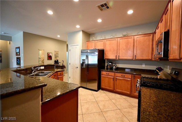 7727 Widewing Dr, North Las Vegas, NV 89084 - kitchen with black fridge with ice dispenser, stainless steel gas range, a sink, recessed lighting, and light tile patterned floors