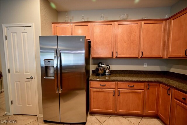 7727 Widewing Dr, North Las Vegas, NV 89084 - kitchen featuring stainless steel fridge with ice dispenser, light tile patterned floors, and brown cabinets