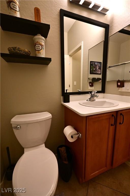 7727 Widewing Dr, North Las Vegas, NV 89084 - half bath with vanity, tile patterned flooring, and toilet