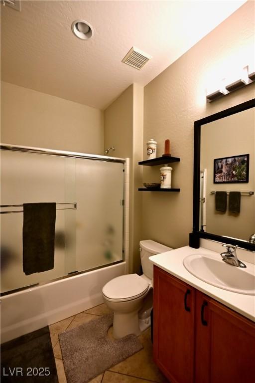7727 Widewing Dr, North Las Vegas, NV 89084 - full bathroom with vanity, toilet, enclosed tub / shower combo, and tile patterned flooring