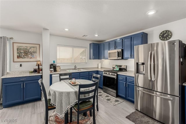 4249 Fleet Dancer St, Las Vegas, NV 89129 - kitchen with stainless steel appliances, blue cabinets, a sink, and recessed lighting